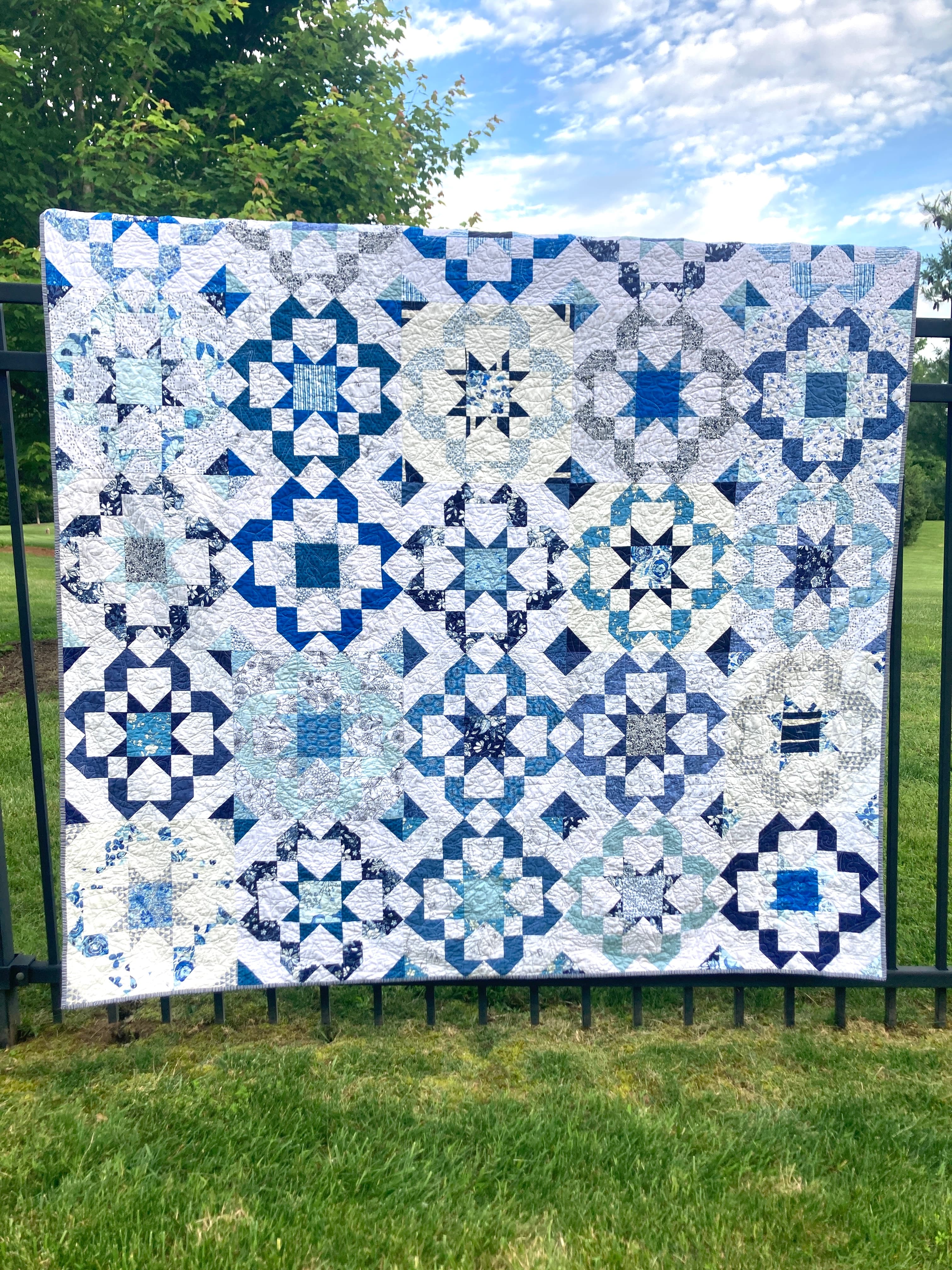 A scrappy quilt in blues with a bloom burst pattern